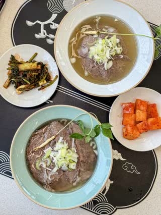 Daega mul naengmyeon, with beef and an edible flower over chilled broth