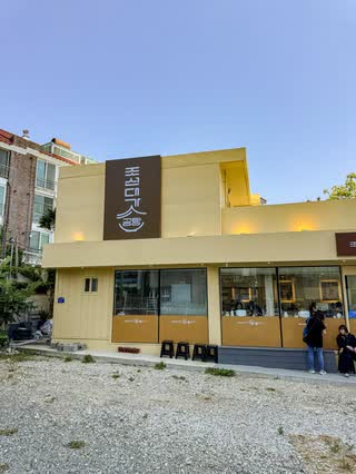 The entrance to JosunDaega Gomtang Haeundae Mipo Branch, with the opening hours on the glass