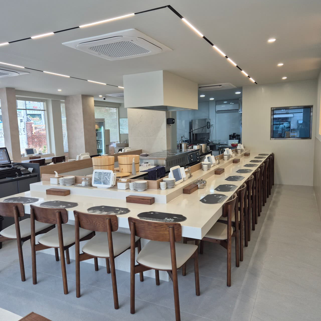 The long counter inside, with wooden chairs and mother-of-pearl patterned mats at each solo seat