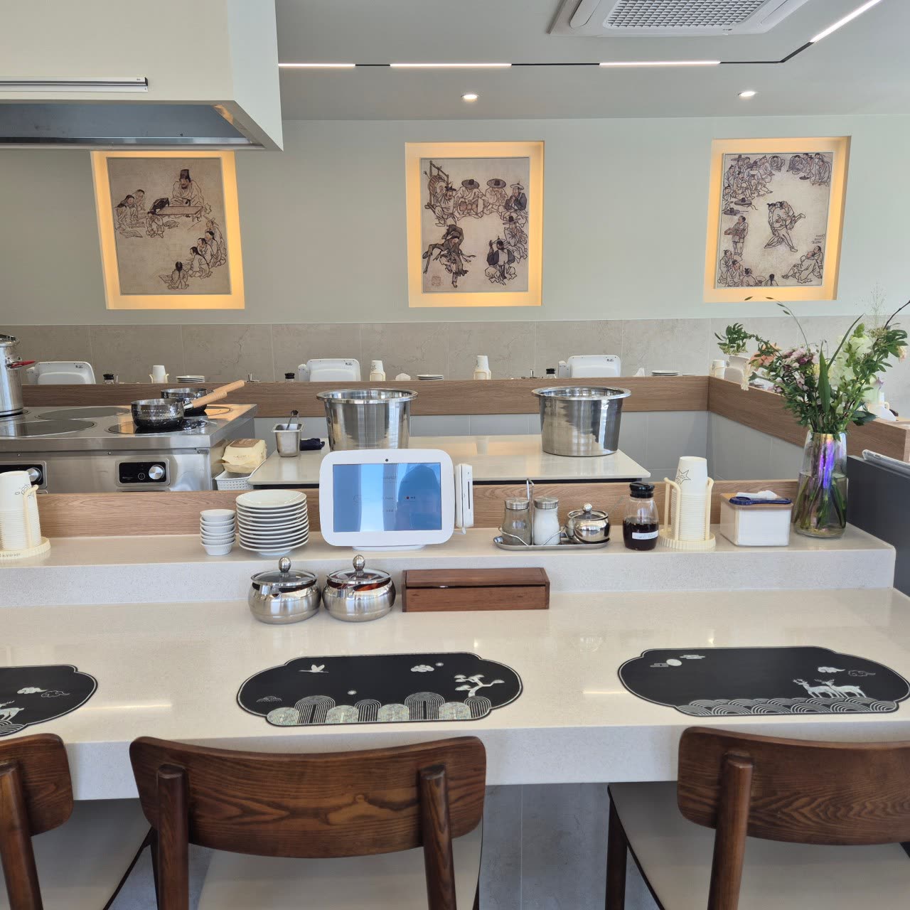 Three Joseon-era folk paintings hung above the open kitchen counter